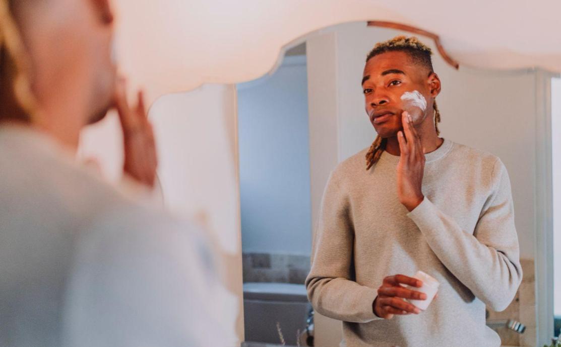Two people applying new skincare actives at home in bright natural light, introducing one active at a time to avoid irritating sensitive skin